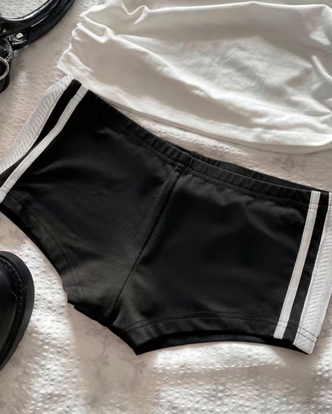 Black mini shorts with white side stripes styled with accessories
