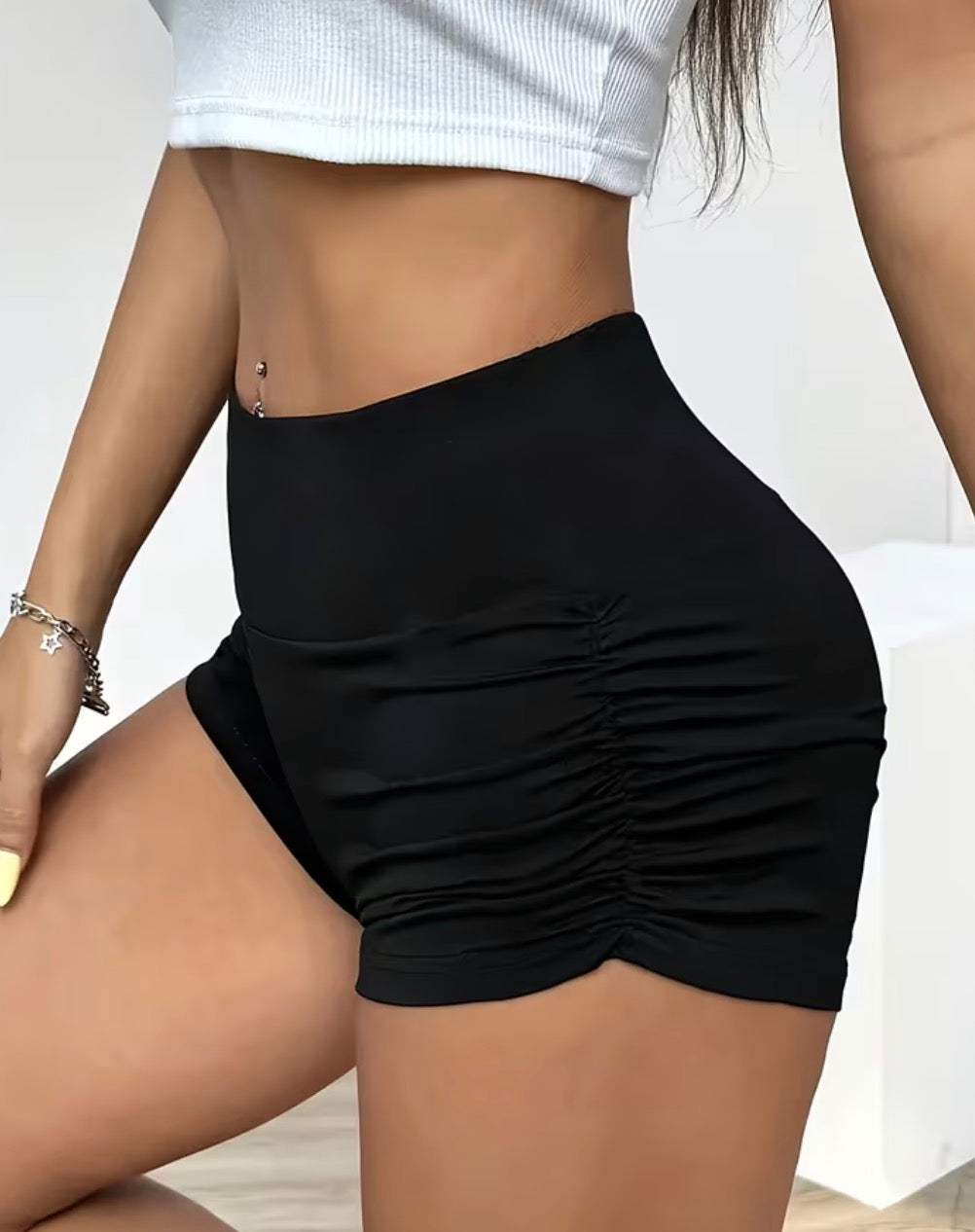 Black high-waisted ruched shorts styled with a white top