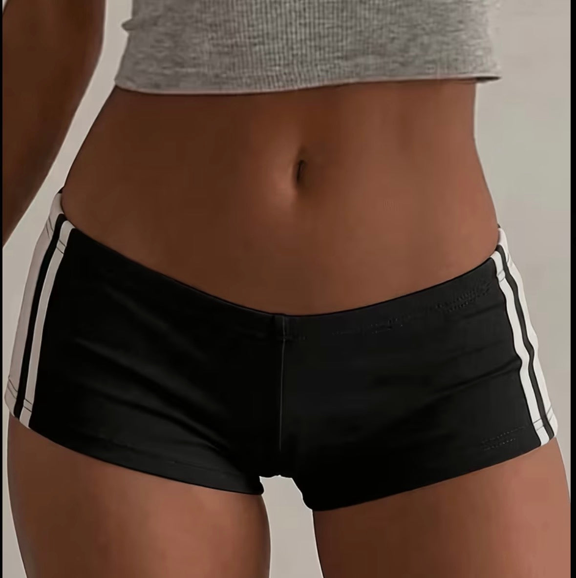 Black and white low-rise mini shorts shown on a model